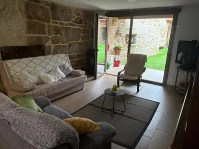 a living room with a couch and a chair at A casita das Pegas