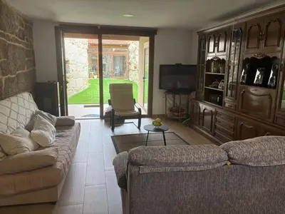 a living room with a couch and a tv at A casita das Pegas