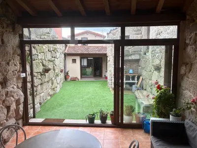 a view of a yard through a large window at A casita das Pegas