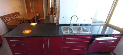 a kitchen with red cabinets and a sink at EnSAN CIPRIAN Con Vistas Al Mar in Cervo