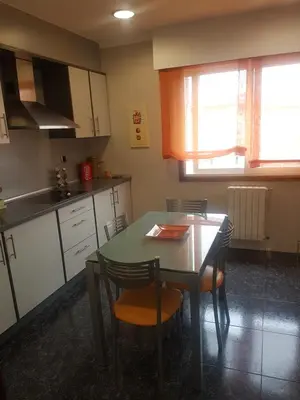 a kitchen with a table and two chairs and a table at EL Descanso in Ourense