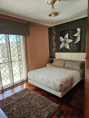 a bedroom with a white bed and a window at EL Descanso in Ourense