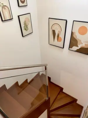 a staircase with a glass rail and pictures on the wall at Viorneira in Milladoiro