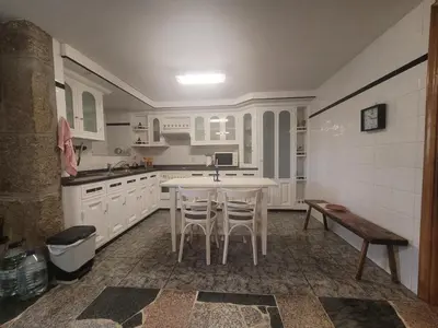 a kitchen with white cabinets and a table and chairs at Casa de López