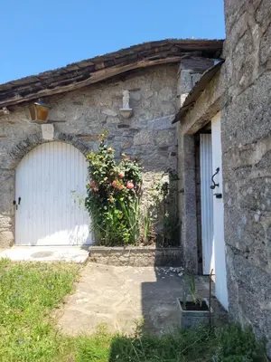 a stone building with a white garage door at Casa de López