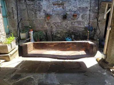 a wooden tub sitting in front of a stone wall at Casa de López