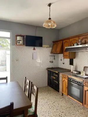 a kitchen with wooden cabinets and a table and a stove at Casa Fonfría in Cabañas