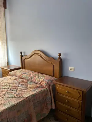 a bedroom with a bed and a wooden dresser at Casa Fonfría in Cabañas
