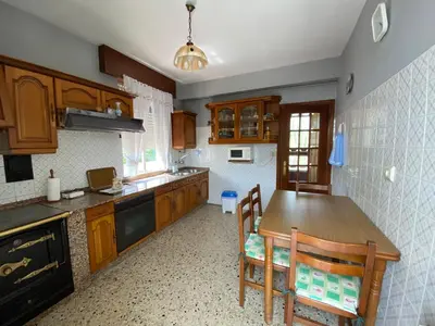 a kitchen with wooden cabinets and a table and chairs at Casa Fonfría in Cabañas