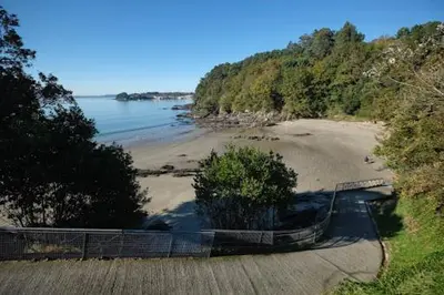 a beach with a fence next to the water at Casa Fonfría in Cabañas