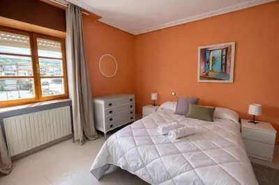 a bedroom with a bed with two nightstands and a painting at Casa Rural Nito - Naturaleza y Descanso en Asturias in Villayón