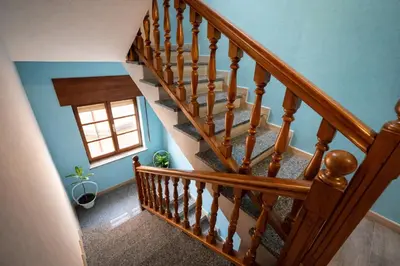 a stair railing with white birds and a painting on the wall at Casa Rural Nito - Naturaleza y Descanso en Asturias in Villayón