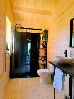 a bathroom with a shower and a toilet and a sink at Cabaña de madera Mar y Madera, playa de las catedrales in Barreiros