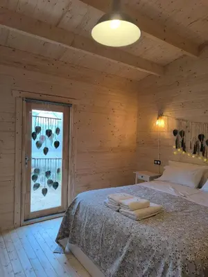 a bedroom with a bed and a window with towels on it at Cabaña de madera Mar y Madera, playa de las catedrales in Barreiros