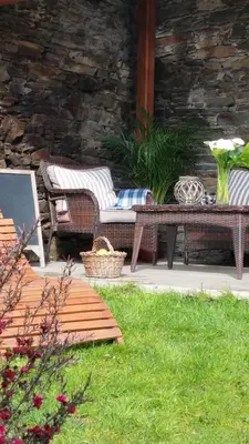 a patio with a table and wicker chairs and a bench at Casa De Aldea La Galea in Vegadeo