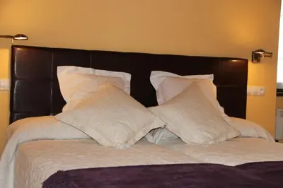 a bed with a black headboard and white pillows at Casa De Aldea La Galea in Vegadeo