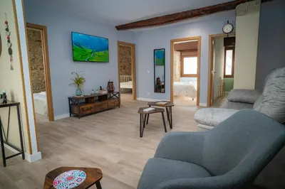 a living room with a couch and a tv on the wall at A Torna in Palas de Rei