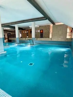 a large swimming pool with blue water at Costa Reinante Spa in San Miguel de Reinante
