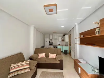 a living room with a couch and a kitchen at Costa Reinante Spa in San Miguel de Reinante