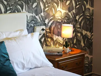 a bed with a lamp on a table next to a bed at O Retiro de Bernardo in Teo