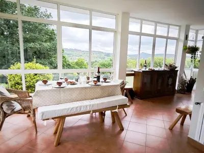 a dining room with a table and large windows at O Retiro de Bernardo in Teo