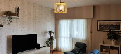 a living room with a flat screen tv and a chandelier at O Retiro de Bernardo in Teo
