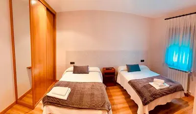 a hotel room with two beds and a mirror at Hostal Restaurante MarRojo Sanabria in Requejo