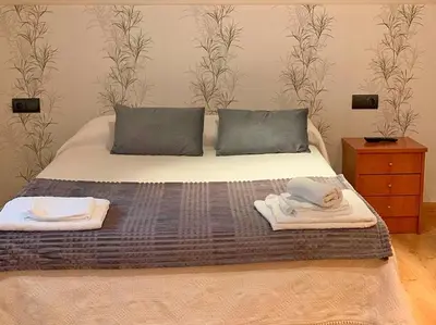a bedroom with a bed with towels on it at Hostal Restaurante MarRojo Sanabria in Requejo