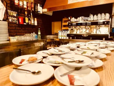 a row of white plates on a table in a restaurant at Hostal Restaurante MarRojo Sanabria in Requejo