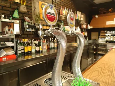 a bar with a counter with bottles of alcohol at Hostal Restaurante MarRojo Sanabria in Requejo