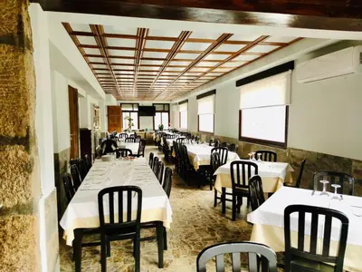 a dining room with white tables and chairs at Hostal Restaurante MarRojo Sanabria in Requejo
