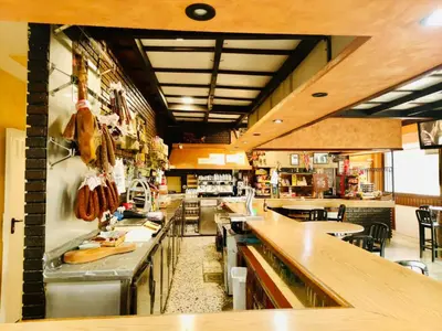 a large kitchen with a long counter in a restaurant at Hostal Restaurante MarRojo Sanabria in Requejo
