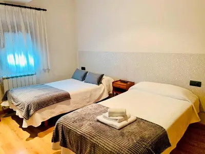 a room with two beds with towels on top of them at Hostal Restaurante MarRojo Sanabria in Requejo
