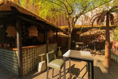 a bar with a table and a chair on a deck at Glam Taoo Hotel Apartamento Boutique in Lugo