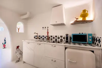 a kitchen with white cabinets and a blue microwave at Glam Taoo Hotel Apartamento Boutique in Lugo