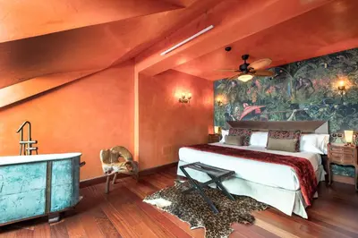 a bedroom with a bed and a bathroom with a tub at Glam Taoo Hotel Apartamento Boutique in Lugo
