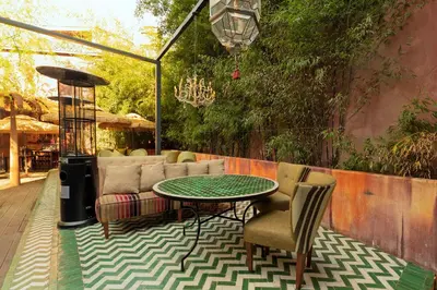 a patio with a table and chairs and a couch at Glam Taoo Hotel Apartamento Boutique in Lugo