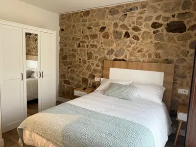 a bedroom with a bed and a large window at A Casa da aldea de Iria in Padrón
