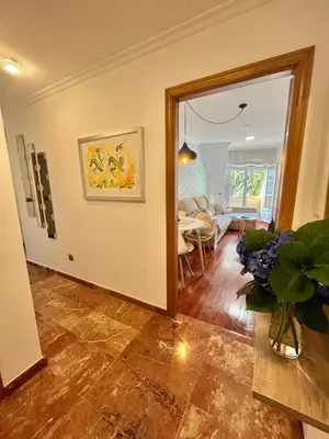 a living room with a vase of flowers on a table at Ático las Palmeras in Caldas de Reis