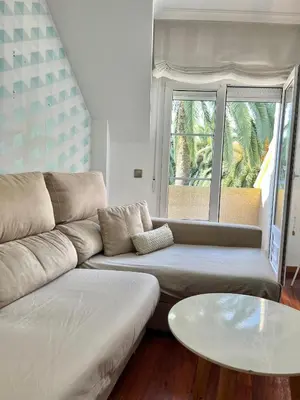 a living room with a couch and a table at Ático las Palmeras in Caldas de Reis