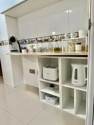 a kitchen with white cabinets and white appliances at Ático las Palmeras in Caldas de Reis