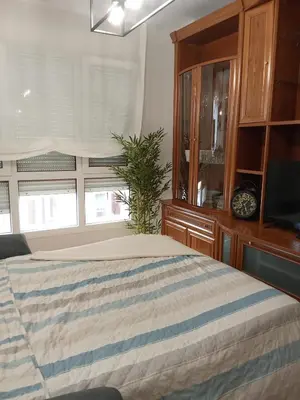 a bedroom with a bed and a tv and a window at San Marcos in Ribadeo