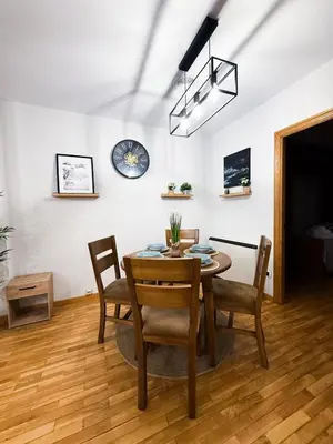 a dining room with a table and chairs and a clock on the wall at San Marcos in Ribadeo