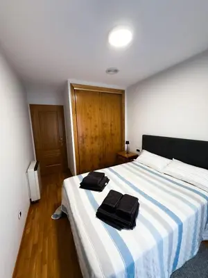 a bedroom with a large bed with two towels on it at San Marcos in Ribadeo