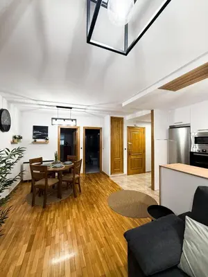 a living room with a table and a kitchen at San Marcos in Ribadeo