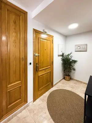 a hallway with a wooden door and a rug at San Marcos in Ribadeo