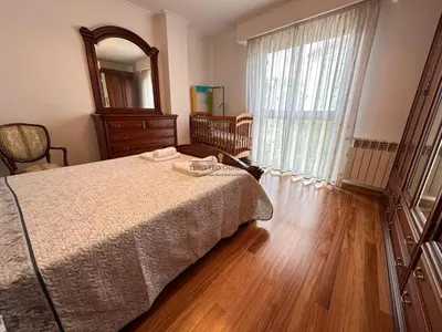 a bedroom with a bed and a dresser and a window at Parque Ávila in Ourense