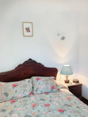 a bed with a floral comforter and a lamp on a table at Casa María in Santa Eulalia