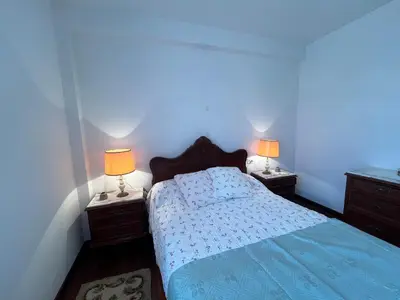 a bedroom with a bed and two night stands with lamps at Casa María in Santa Eulalia