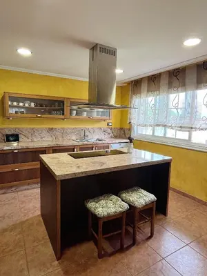 a kitchen with a large island with two stools at Casa María B in Santa Eulalia